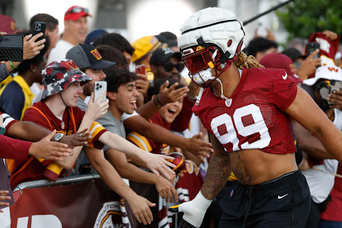 Washington Commanders defensive end Chase Young (99) shakes hands with fans while walking to the fields prior to day two of Commanders training camp at OrthoVirginia Training Center.
